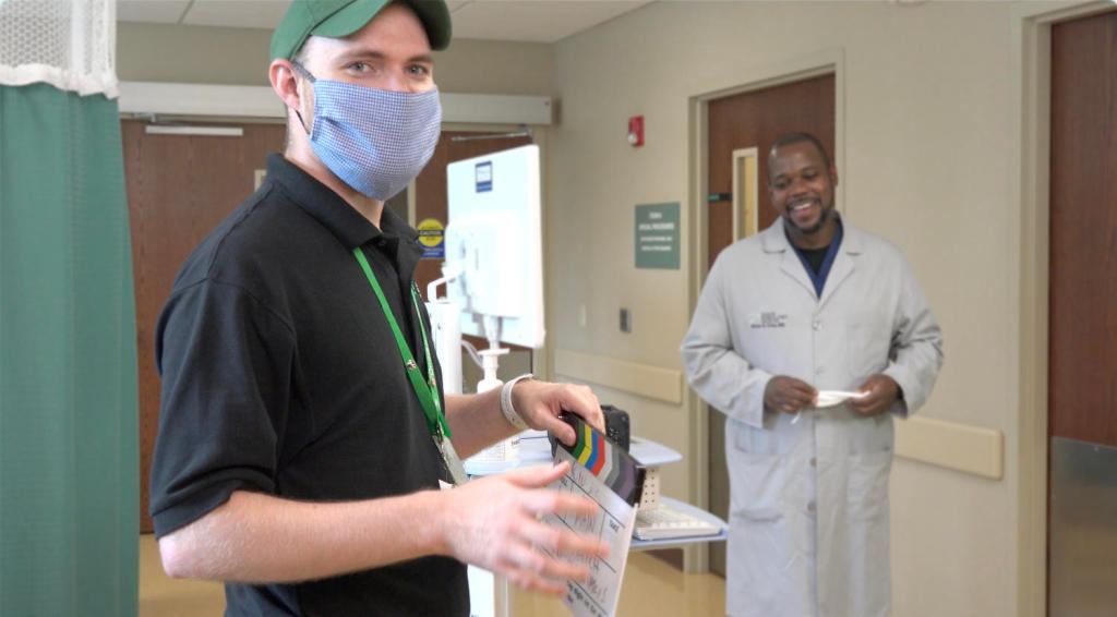Nick Sarantakis films a television commercial in the hallway of an outpatient surgery center, with a doctor in a labcoat smiling in the background.